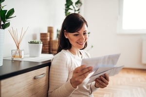 woman looking at mail in cozy home