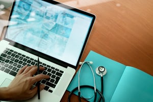 close up of a doctor browsing on a laptop