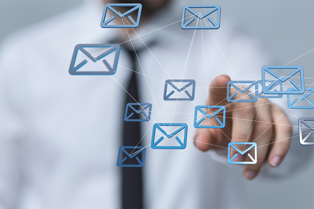 multiple email icons in front of blurred out office worker